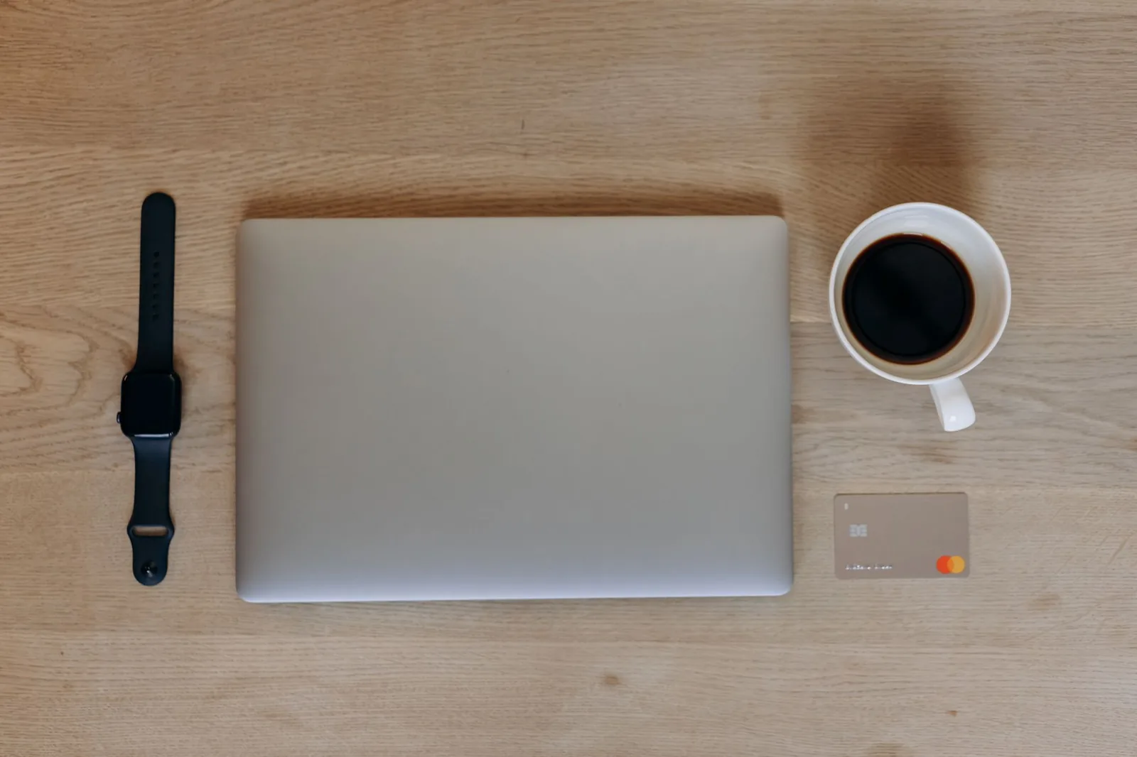 Laptop, coffee cup, and credit card on a desk