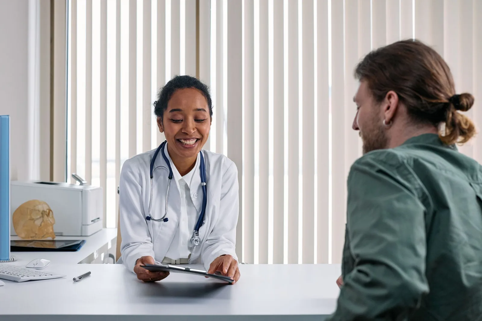 A doctor and patient talking during a calm consultation in a bright clinic before a scan.