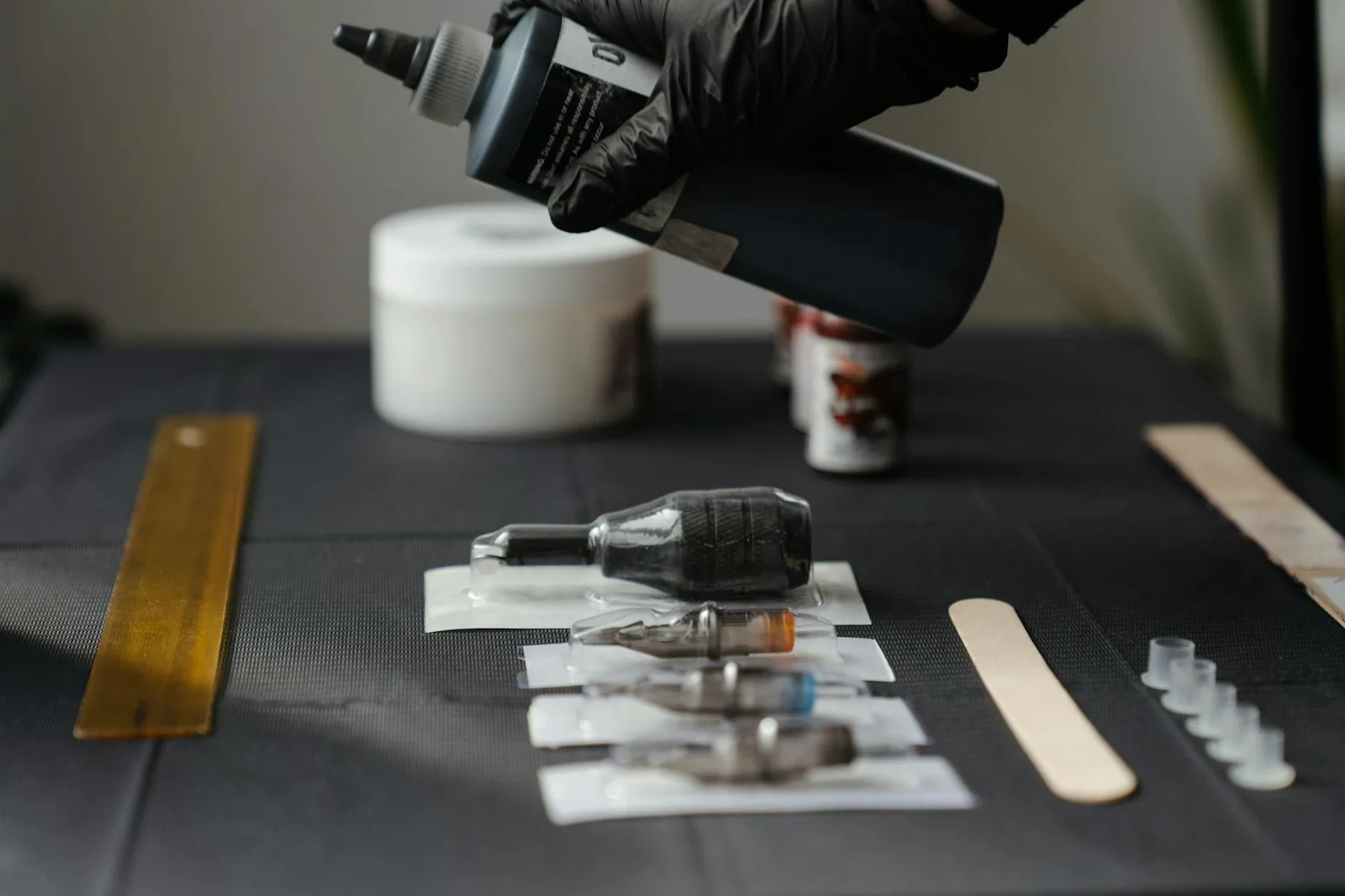Close-up of tattoo equipment and ink in a studio, showing tools and preparation.