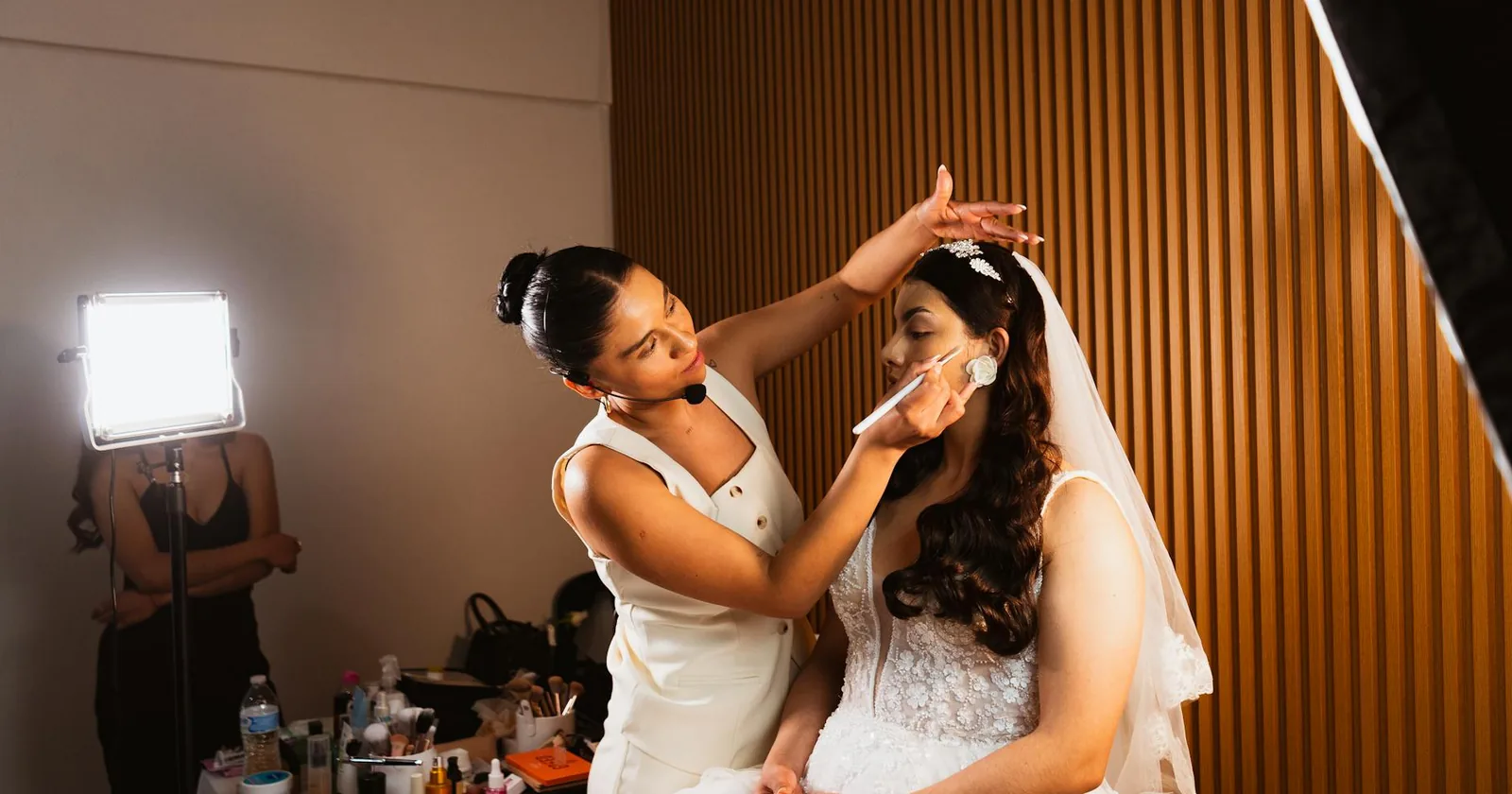 Bride having her bridal makeup applied in soft natural light, with attention on her eyebrow shape.